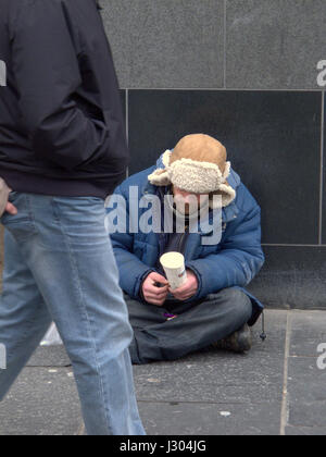 obdachlos in den uk Betteln auf der Straße mit Trapper Hut weißen kaukasischen Armee Soldat Typ Stockfoto