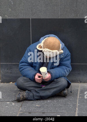 obdachlos in den uk Betteln auf der Straße mit Trapper Hut weißen kaukasischen Armee Soldat Typ Stockfoto