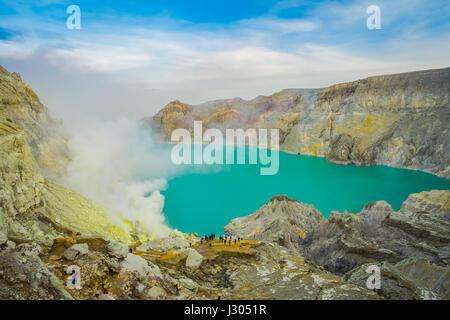 KAWEH IJEN, Indonesien: Spektakuläre Überblick über vulkanische Kratersee mit schönen blauen Himmel, Touristen, die in der Ferne sichtbar Stockfoto