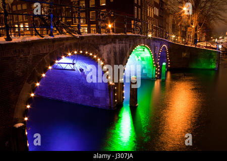 Brücke über den Kanal in Amsterdam bei Nacht erleuchtet Stockfoto