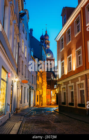 Riga, Lettland. Blick auf einsamen gepflasterten Kramu Gasse der Altstadt In der Abendhelle Beleuchtung mit antiker Architektur führenden Dom Dome Stockfoto