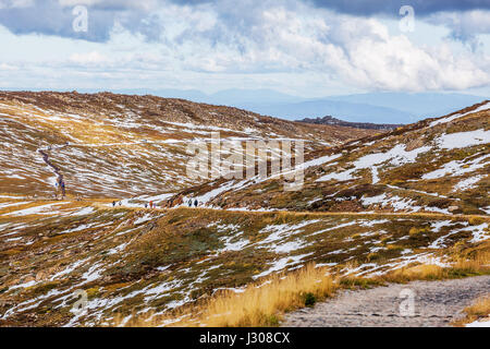 Menschen zu Fuß auf den Gipfel von Mount Kosciuszko gehen. Snowy Mountains, Australien Stockfoto