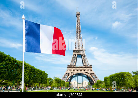 Französische Flagge vor dem Eiffelturm in Paris, Frankreich auf ein strahlend blauer Himmel Frühlingstag Stockfoto