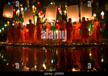 CHIANG MAI, THAILAND - 7. November 2014: Junge buddhistische Mönche in orangefarbenen Gewändern starten Himmelslaternen beim jährlichen Yi Peng Festival. Stockfoto