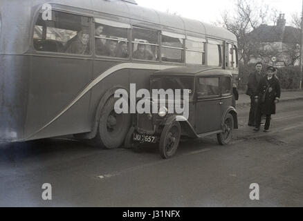 1950, ein Passagierbus Doppeldeckerbusse bei einer Kollision mit einem kleinen Pre-ww2 Austin 7 Motorwagen, England, UK. Stockfoto