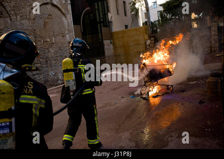 Barcelona, Spanien. 1. Mai 2017. 1. Mai 2017 - Barcelona, Katalonien, Spanien - Feuerwehrleute löschen brennende Einkaufswagen während einer Maifeiertag antikapitalistische Demonstration in Barcelona. Bildnachweis: Jordi Boixareu/Alamy Live-Nachrichten Stockfoto