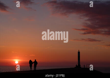 Aberystwyth Wales UK, Montag, 1. Mai 2017 UK Wetter: am Ende der der kann Bank Holiday Montag, Menschen zu Fuß entlang des Hafens Wand genießen den warmen Abend und beobachten den Sonnenuntergang spektakulär über die ruhigen Gewässer der Cardigan Bay aus Aberystwyth auf West Wales Küste Photo Credit: Keith Morris/Alamy Live-Nachrichten Stockfoto