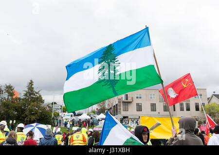 Seattle, USA. 1. Mai 2017. Unterstützer fliegen CascadiaNow! und kommunistischen Partei Fahnen während der Rallye in Judkins Park am Maifeiertag März für Arbeitnehmer und Einwanderer Rechte. Veranstalter rief zum Generalstreik am International Workers Tag in Solidarität mit koordinierten Veranstaltungen in Gemeinden in den Staat Washington und auf der ganzen Welt. Bildnachweis: Paul Gordon/Alamy Live-Nachrichten Stockfoto