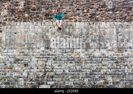 Touristen fotografieren aus Spitze einer Pyramide in der Maya-Ruinen von Uxmal in Mexiko Stockfoto