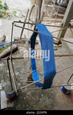 Handwerkliche Doppel Spinnrad mit blauen Faden. Ban Xang Khong Dorf der Menschen spezialisiert auf Seidenweberei und der Herstellung von Saa-herkömmlichen Lu Stockfoto