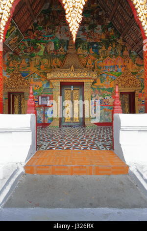 SIM-Eingang-Wat Xieng Muan Kloster-Giebelseite geschnitzt mit geometrischen Mustern-innere Decke Schablonen mit gold Naga-Wände gemalt in Gold mit sc Stockfoto