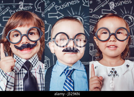 Collage von Porträts von Kindern im Stil des Geschäfts. Kinder in Gläsern auf einem schwarzen Hintergrund mit Diagrammen. Stockfoto