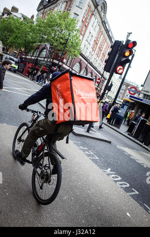 Ein Bigfoodie Fahrrad Essen Lieferung Kurier eilt durch den Verkehr im Zentrum von London. Bigfoodie konkurrieren mit Deliveroo und Uber isst Stockfoto