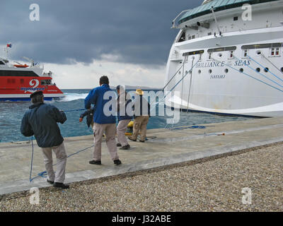 Kreuzer Arbeiter in Aktion - Gruppe von Menschen, die ziehen die Seile des riesigen Cruiser versenden. Insel Mykonos, Kykladen, Griechenland Stockfoto