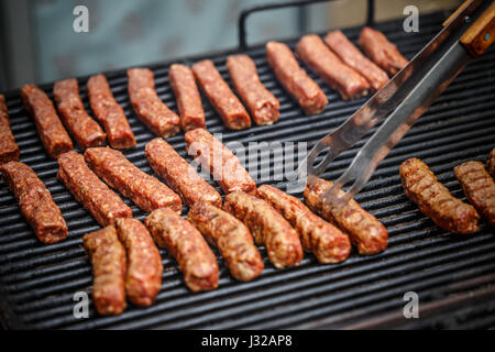 Gehacktem Schweinefleisch rollt über grill Stockfoto