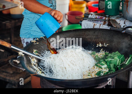 GEORGE TOWN, MALAYSIA - 23 März: Frau kocht gebratene Nudeln mit Sojasprossen an Kimberly Street Food Night Market am 23. März 2016 in George Stockfoto