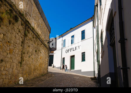 Porto Wine Lodge, Blick auf ein Paar, das sich auf den Weg zu einer Portwein-Lodge hinter dem Wasser in der Gegend von Vila Nova de Gaia in Porto, Portugal, macht. Stockfoto