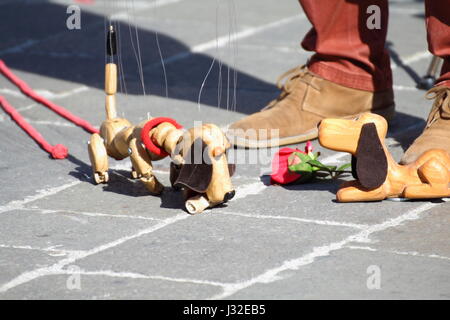 Traditionelle Puppen aus Holz gebaut. Marionette in Form des Hundes durch den Menschen bewegt. Stockfoto