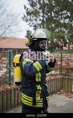 Deutscher Feuerwehrmann im Freien in Aktion und mit Sauerstoff-Flasche und Maske Stockfoto