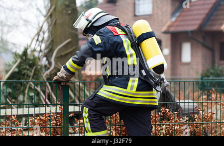 Deutscher Feuerwehrmann im Freien in Aktion und mit Sauerstoff-Flasche und Maske Stockfoto