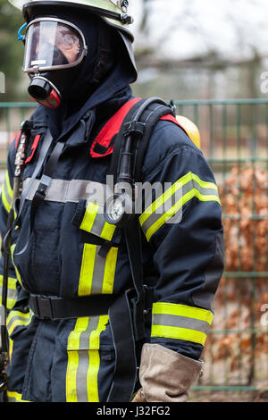 Deutscher Feuerwehrmann im Freien in Aktion und mit Sauerstoff-Flasche und Maske Stockfoto