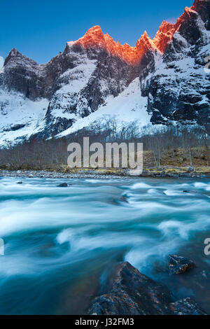 Sonnenlicht am frühen Morgen auf der 1000 Meter hohen Trollveggen-Mauer und den Gipfeln Trolltinden im Romsdalen-Tal, Norwegen. Stockfoto