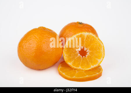 Ganze und geschnittene Clementine Früchte in weißen Hintergrund isoliert. Stockfoto