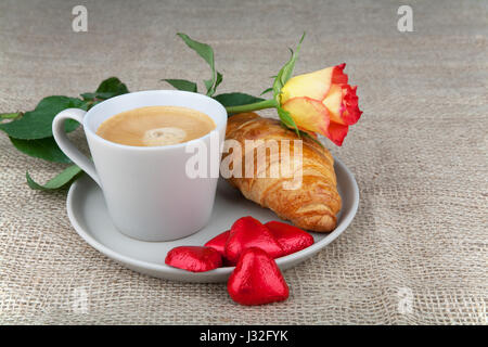 Kaffee, Croissants, Herz Schokolade in einer roten und rot-gelbe rose Stockfoto