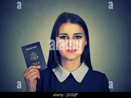 Porträt attraktive junge glücklich Frau mit USA Reisepass auf graue Wand Hintergrund isoliert. Positive Emotionen Gesicht Ausdruck. Einwanderung-Reisen Stockfoto