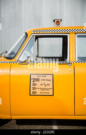 Seitenansicht des Fahrers des mittleren Teils des Vintage gelb Checker Taxi, skizziert eine gewellte Metall Wand Stockfoto