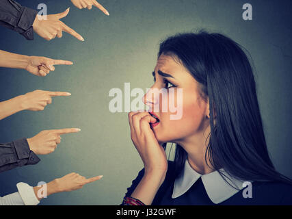 Ängstliche Frau beurteilt durch verschiedene Hände. Konzept der Anklage schuldig Mädchens. Negative Emotionen Gesicht Ausdruck Gefühl Stockfoto