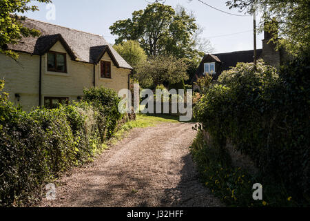 Ein Ferienhaus aus Stein / Haus mit Verputzte Außenwände in der englischen Landschaft an einem sonnigen Tag. Kiesweg. In der Regel malerischen englischen Szene. Stockfoto