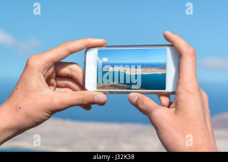 Hautnah auf Händen mit einem Smartphone zu fotografieren, in Lanzarote, Spanien Stockfoto