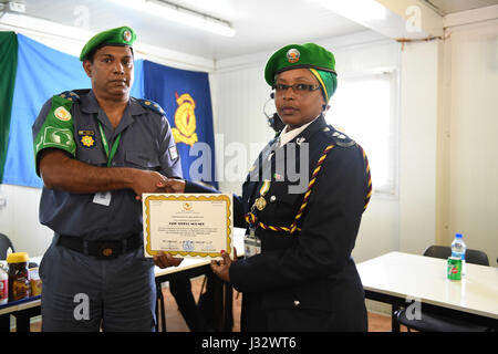 AMISOM Commissioner of Police Brigadier Anand Pillay stellt eine Bescheinigung über die Anerkennung für Inspector Jane Mwelu, als ein einzelner Polizist (IPO) während einer Medaillen-Preisverleihung in Mogadischu auf February18, 2017 gedient hat. AMISOM Foto/Atlinda Allan Stockfoto