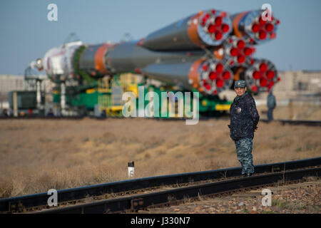 Russische Sicherheitsoffizier gilt als das Raumschiff Sojus MS-04 zur Startrampe mit dem Zug auf Montag, 17. April 2017 am Weltraumbahnhof Baikonur in Kasachstan wird ausgerollt.  Start der Sojus-Rakete ist für 20. April geplant und führt Expedition 51 Sojus-Kommandant Fyodor Yurchikhin von Roskosmos und Flugingenieur Jack Fischer von der NASA in den Orbit zu beginnen, ihre vier und einen halben Monat Mission auf der International Space Station.Photo Credit: (NASA/Aubrey Gemignani) Stockfoto