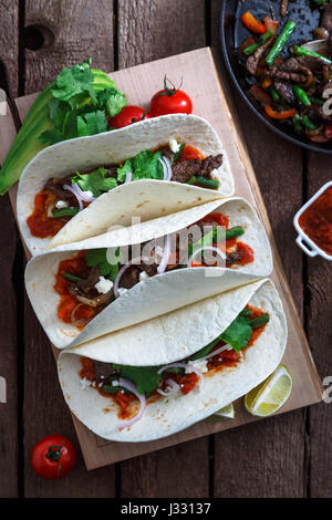 Mexikanische Fajitas mit Rindfleisch und gegrilltem Gemüse Paprika, rote Zwiebel, Tomate. Ansicht von oben Stockfoto