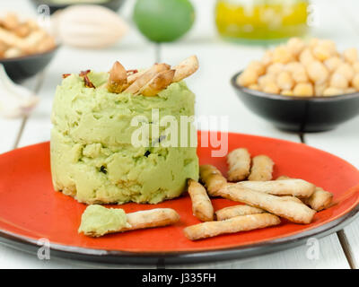 Avocado Hummus mit Mini Grissini, rustikale Stillleben Stockfoto