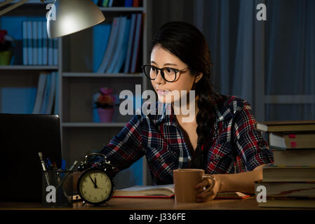 Junge Asiatin konzentriert in Gläser mit Computer für studieren und am Abend zu Hause schreiben. Gemischte Rassen asiatische chinesische Modell. Stockfoto