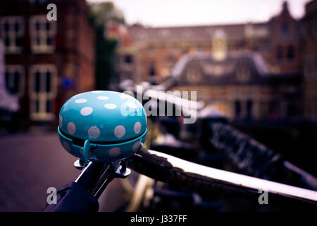 Polka punktiert blau Fahrradklingel mit Amsterdam Altbauten im Hintergrund Stockfoto