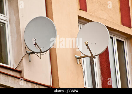 Satellitenschüsseln an einer externen Hauswand hängen Stockfoto