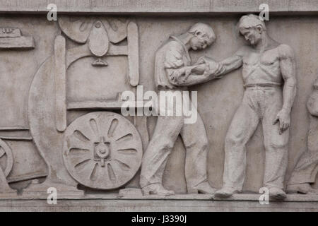 Unfall in der Holzbe-und verarbeitenden Industrie. Relief von dem ungarischen Bildhauer Gyula Maugsch (1930) am Nordflügel des Art-Déco-Gebäudes von Budapest Arbeitnehmer Krankenkasse in Budapest, Ungarn. Das Gebäude, nun als Sitz der nationalen Sozialversicherung Zentrum (OTI), wurde von ungarischen Architekten Marcell Komor und Dezsö Jakab entworfen und im Jahre 1913 gebaut. Der Nordflügel wurde vom Architekten Aladar Sos 1930-1931 hinzugefügt. Stockfoto