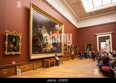 ST. PETERSBURG, Russland - ca. April 2017: Leute sitzen auf den Bänken in der Nähe von Bild von "Der letzte Tag von Pompeji", Künstler Karl Bryullov. Innenraum der S Stockfoto