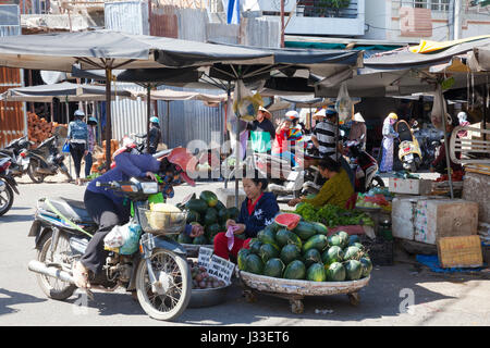 NHA TRANG, VIETNAM - Dezember 12: Frau Star Äpfel und Wassermelonen auf dem nassen Markt am 12. Dezember 2015 in Nha Trang, Vietnam verkauft. Stockfoto