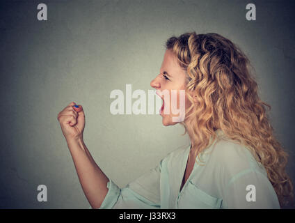 Böse Frau schreiend mit Faust sich in Luft Stockfoto