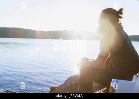 Junger Mann, bewundern Sie die Aussicht an einem malerischen See Stockfoto