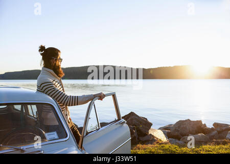 Junger Mann, bewundern Sie die Aussicht an einem malerischen See Stockfoto