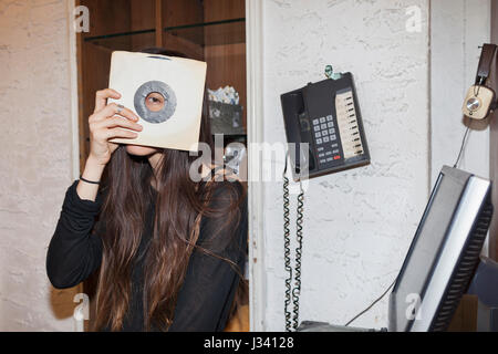 Junge Frau in einem Plattenladen Alben erfasst Stockfoto