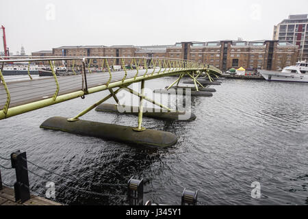 London, UK, 1. April 2017 - Fußgängerbrücke in Canary Wharf in London Docklands zu arbeiten. Die Fußgängerbrücke wird von Menschen benutzt, um das Hafengebiet zu überqueren Stockfoto