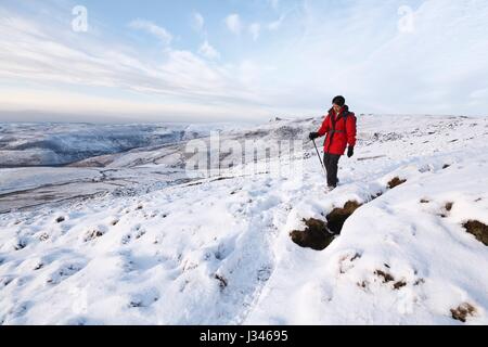 Indische Frau Wandern im Winterschnee, Peak District, UK Stockfoto