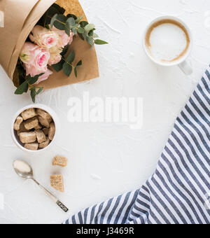 Romantische weibliche Hintergrund mit Kaffee und Rosen auf weiße strukturierte Tabletop, elegante leichte flatlay Stockfoto